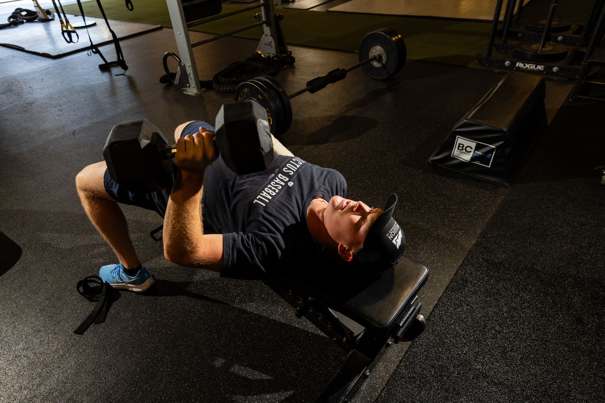 Athlete pressing dumbbells on a bench