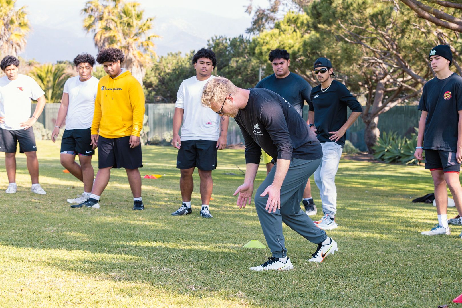 Coach demonstrating a drill to a group of athletes